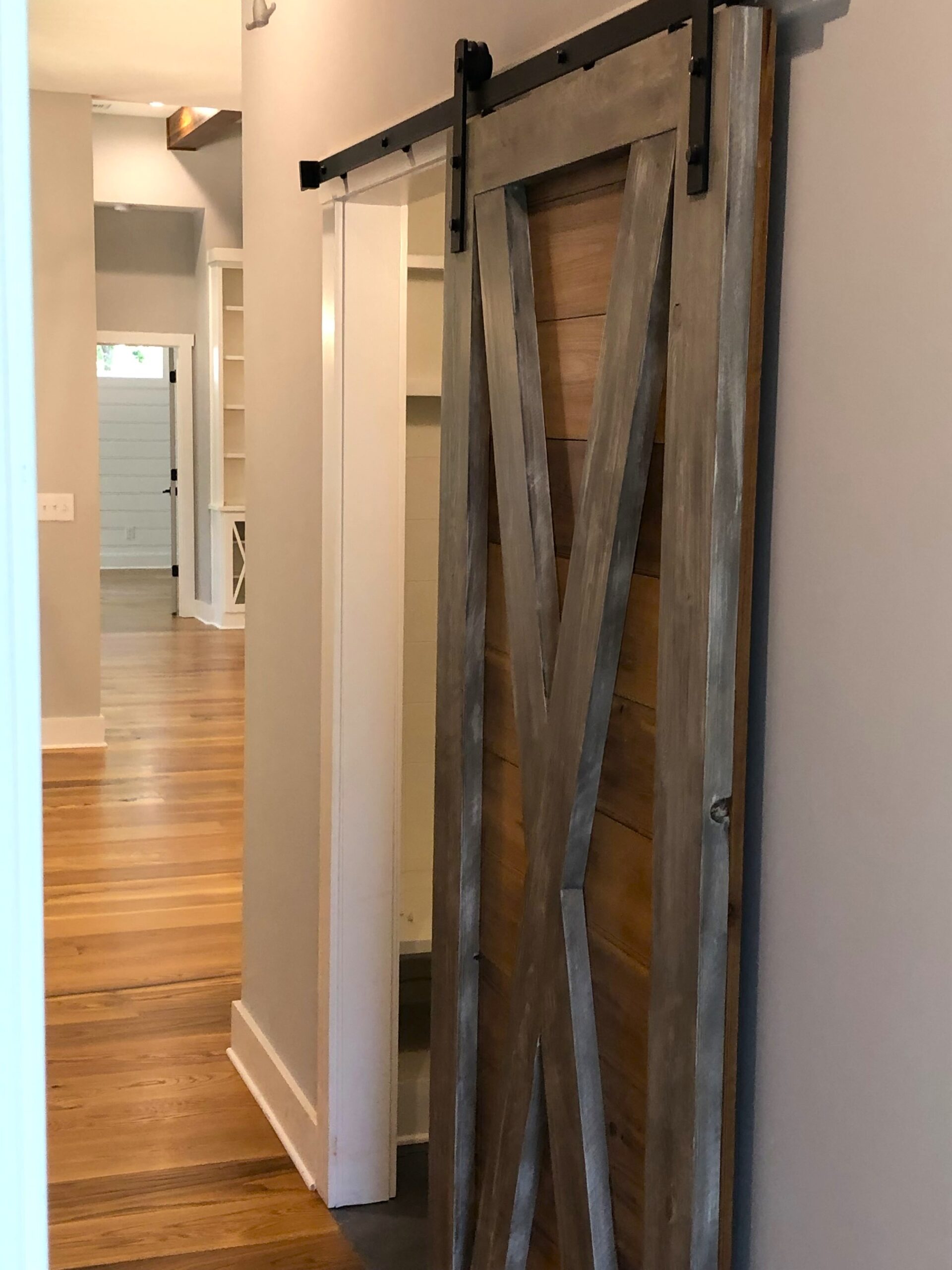 Completed installation of a barn door entering a walk in closet.