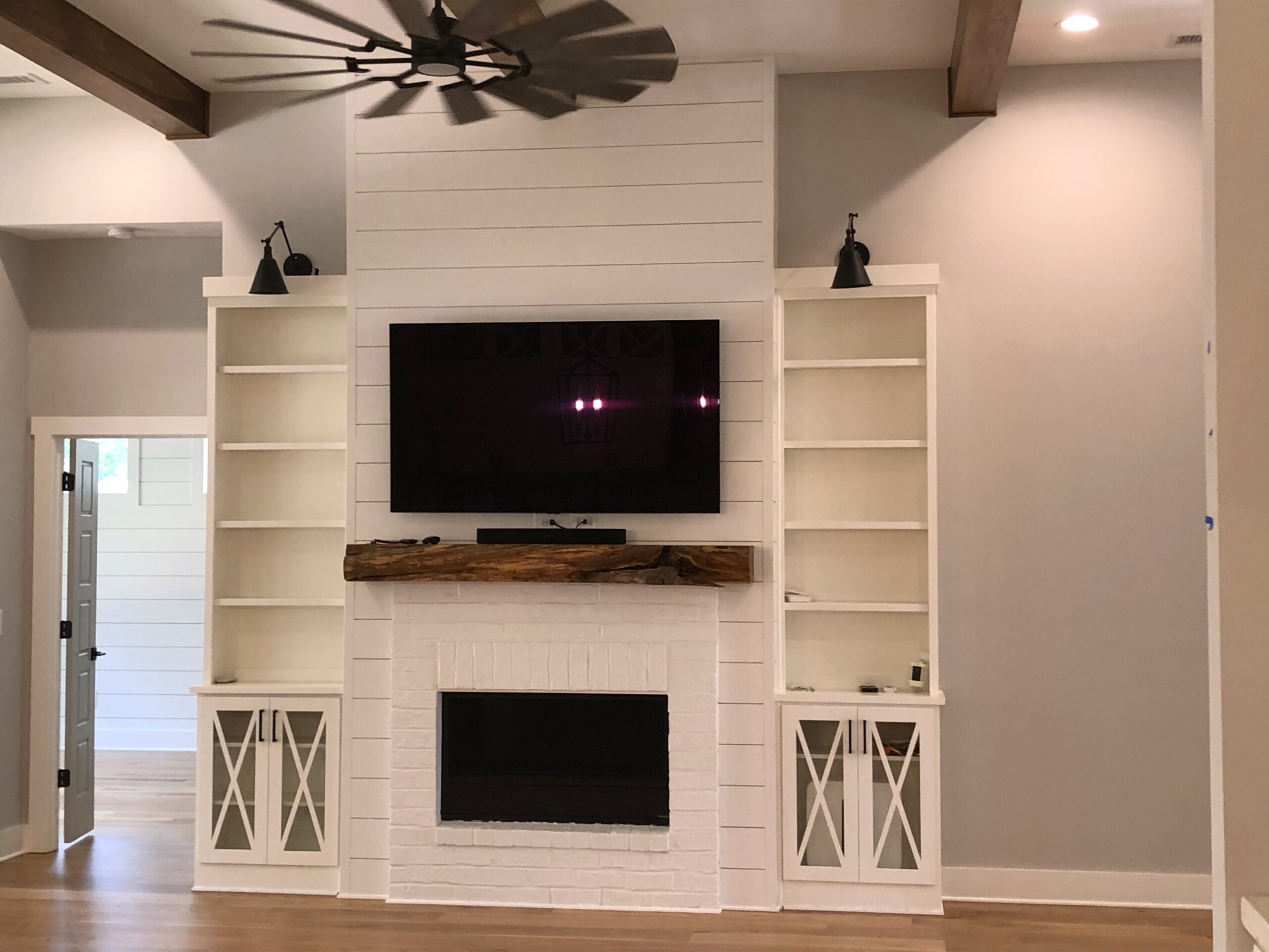 A completed renovation of a client's common area or living room, which shows added shelves and mantle.